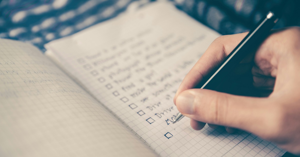 Person writing a self-care checklist to build a repeatable routine